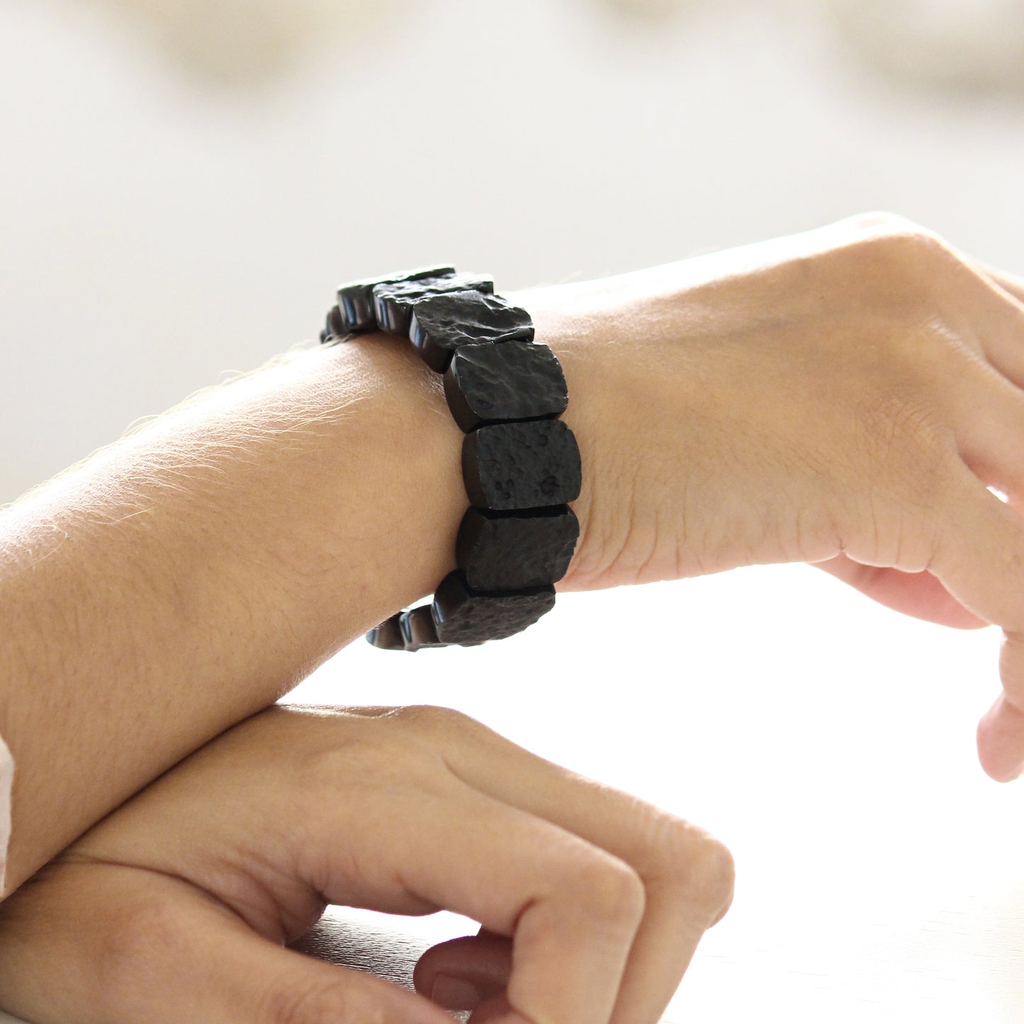 black tektite beaded bracelet on model's hand